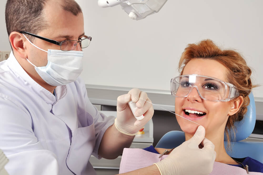 West Miami Dentist teaching a patient how to floss